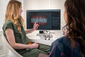 Dental consultation showing 3D model explaining teeth implants cost in Melbourne